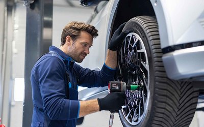 Ein Service-Mitarbeiter wechselt in der Werkstatt die Reifen eines Fahrzeugs. Das Bild steht für den professionellen Hyundai Winterservice bei S&G – optimal vorbereitet auf Schnee, Eis und kalte Temperaturen.